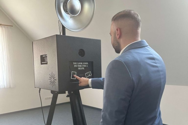 Person klickt auf den Touchscreen der Fotobox, um eine Aufnahme zu starten, ideal für interaktive Nutzung auf Events und Feiern.